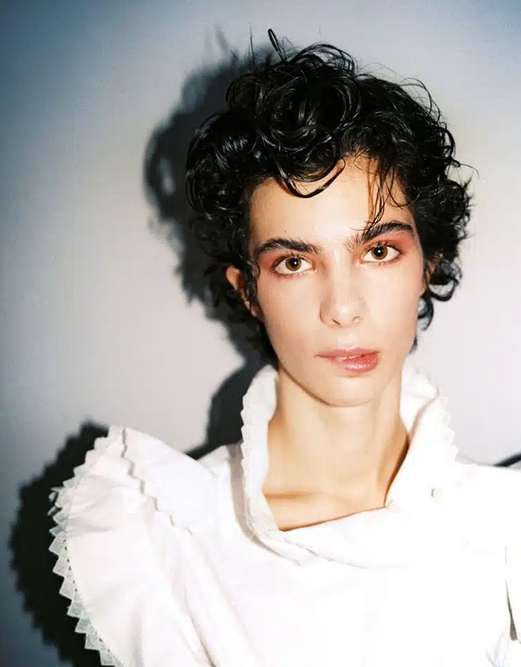 Beauty portrait with curly hair and a white ruffled top