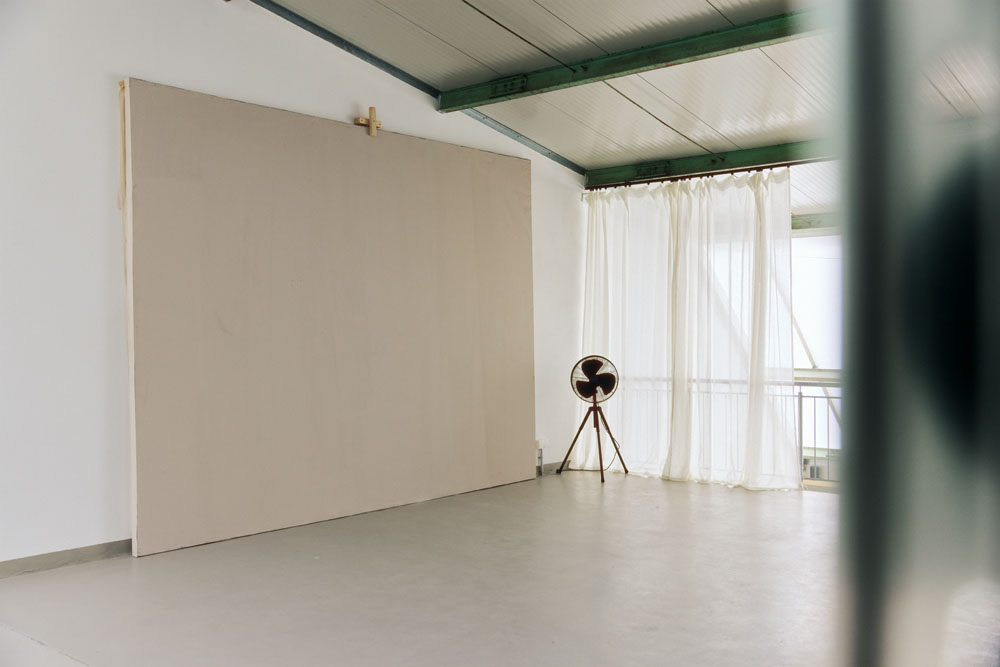 Beige backdrop in front of window with fan