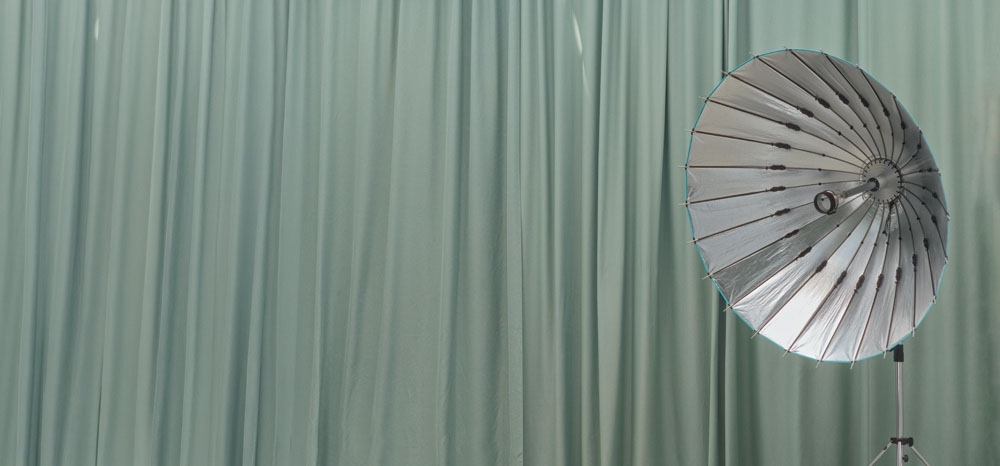 Green studio curtain with silver para umbrella